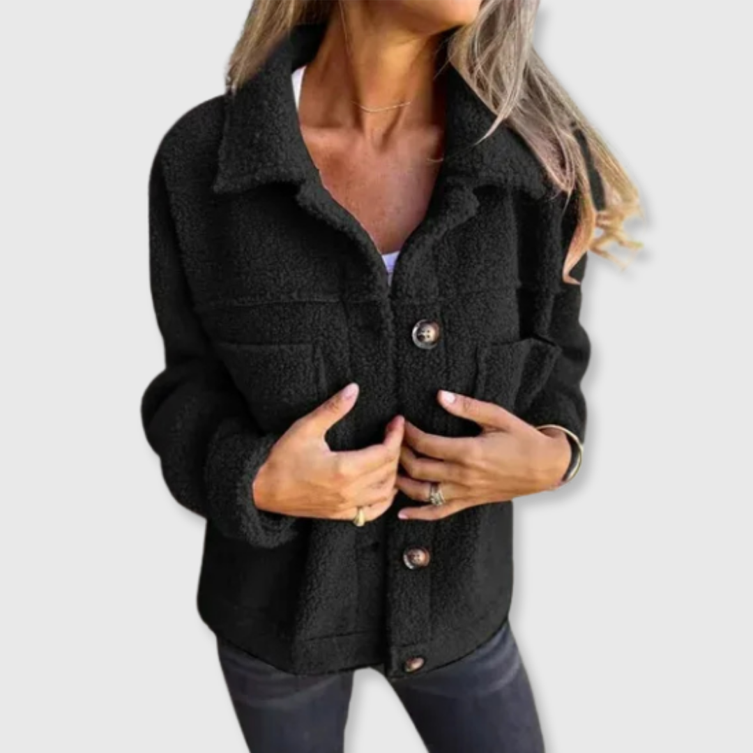 Black sherpa-style coat with button closure and chest pockets, worn open at front.