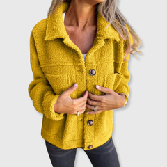 Yellow sherpa-style coat with button closure and chest flap pockets, worn open at front.