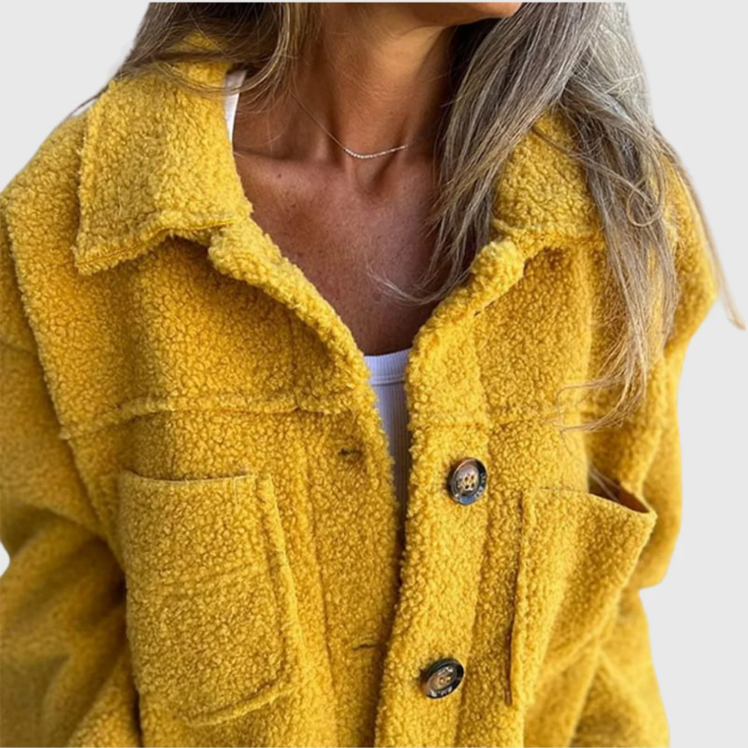 Close-up of yellow sherpa-style coat with button placket and round metal-look buttons.