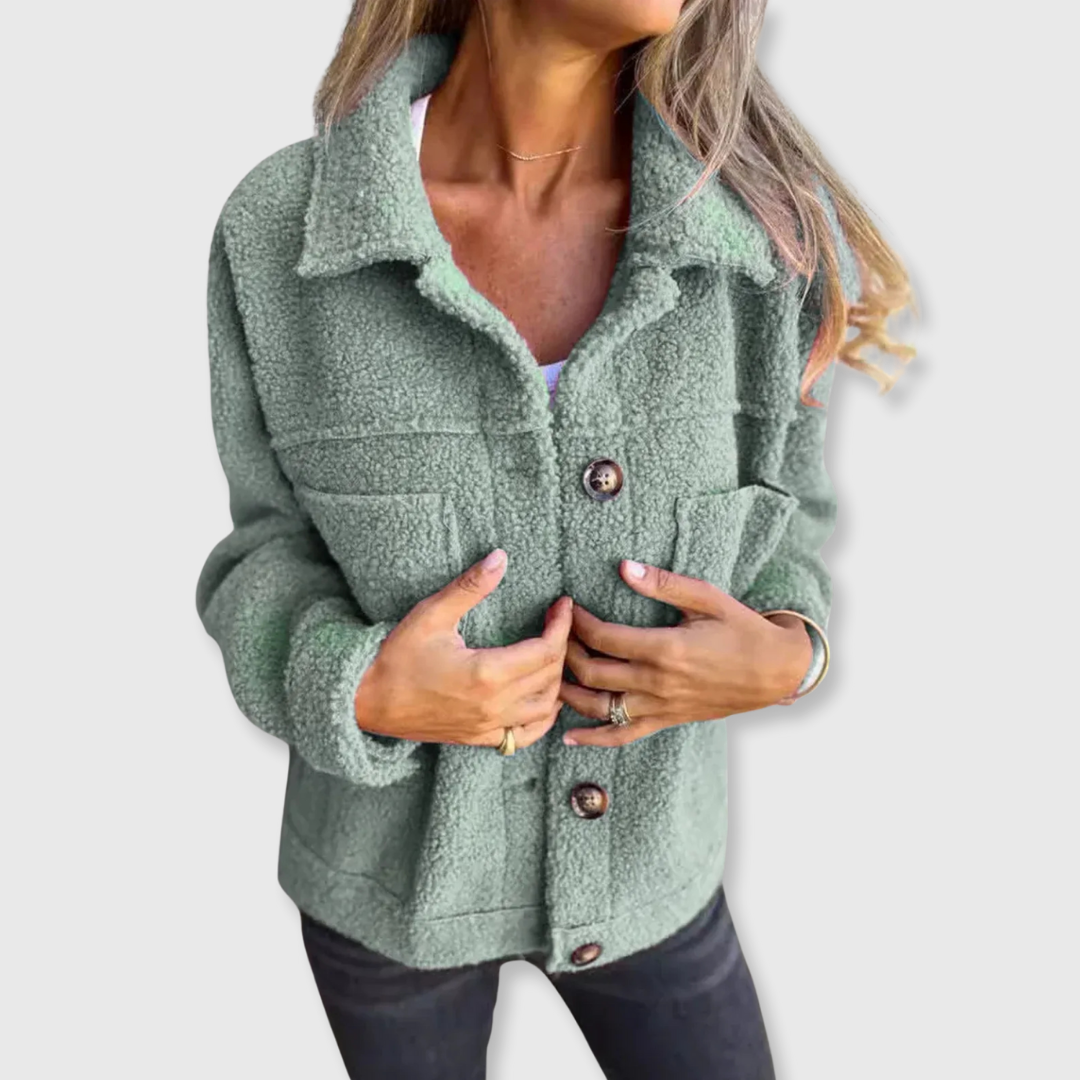 Green sherpa-style coat with button closure and two flap pockets, worn open at front.