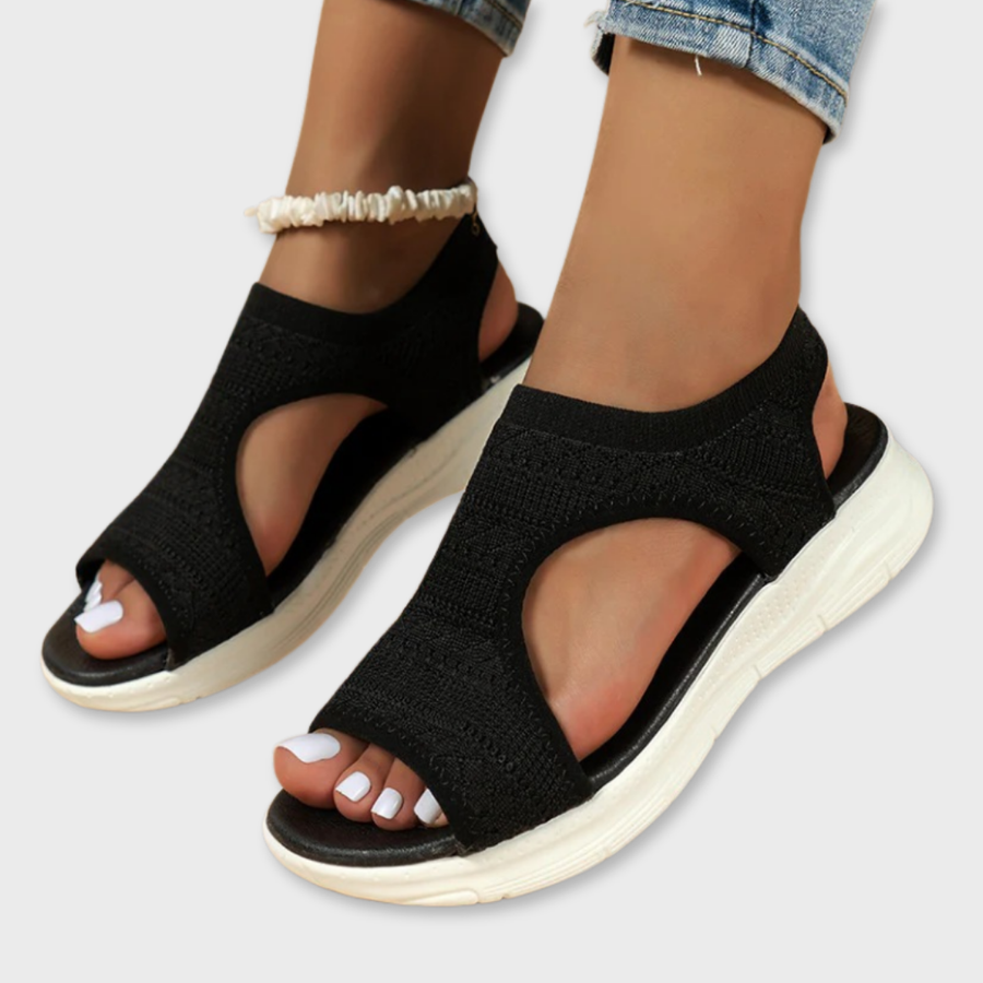 Black knit slide sandals with cross strap and white cushioned sole