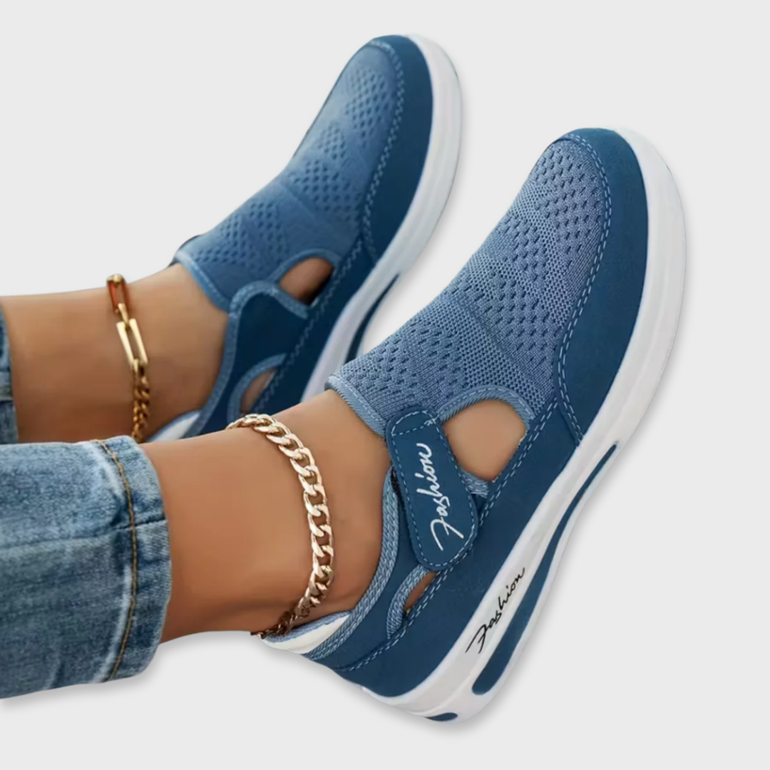 Blue perforated comfort sneakers with side cutout, elastic strap, and white sole