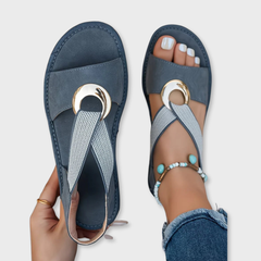 Blue flat sandals with mesh straps and round gold-tone metal buckle