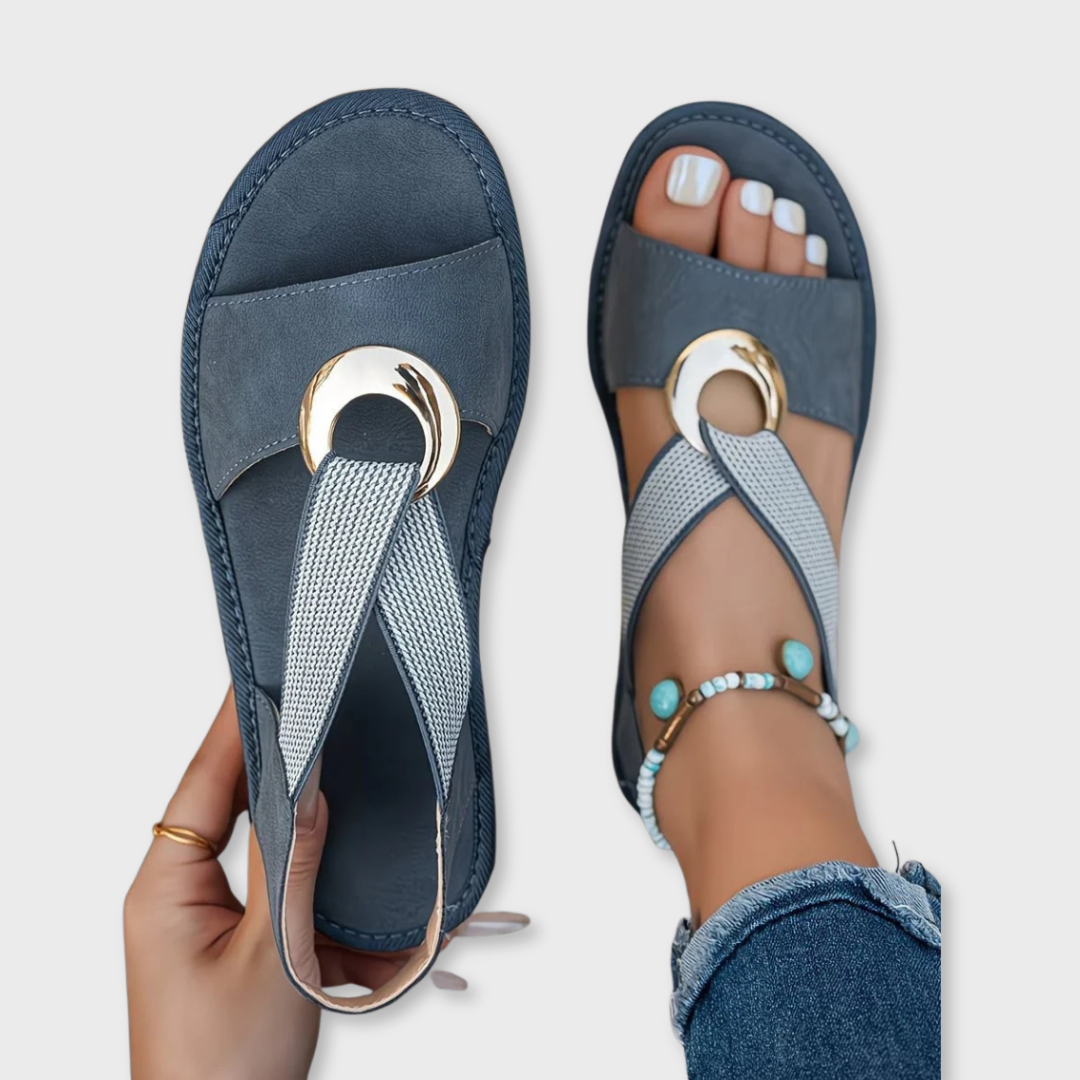 Blue flat sandals with mesh straps and round gold-tone metal buckle
