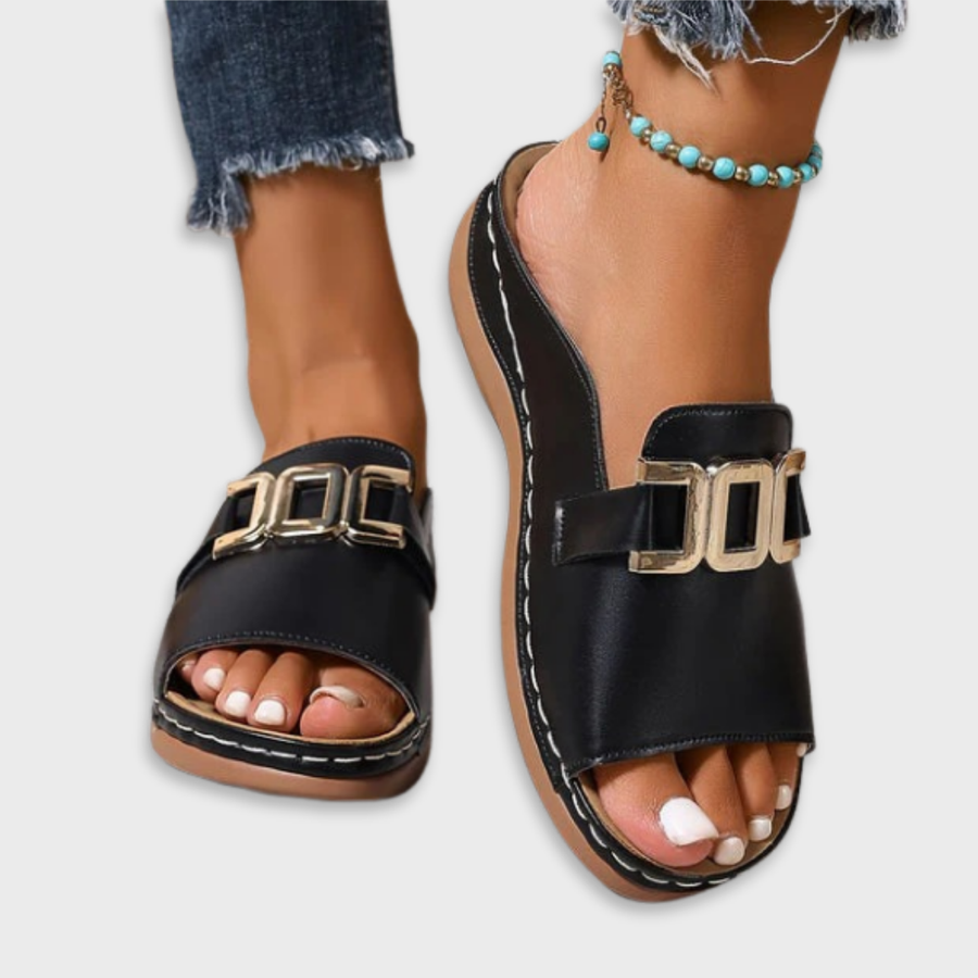 Black open-toe sandals with double front buckle straps and cushioned footbed