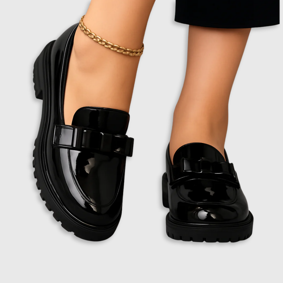 Black patent loafers with chunky block heel and buckle strap across the vamp