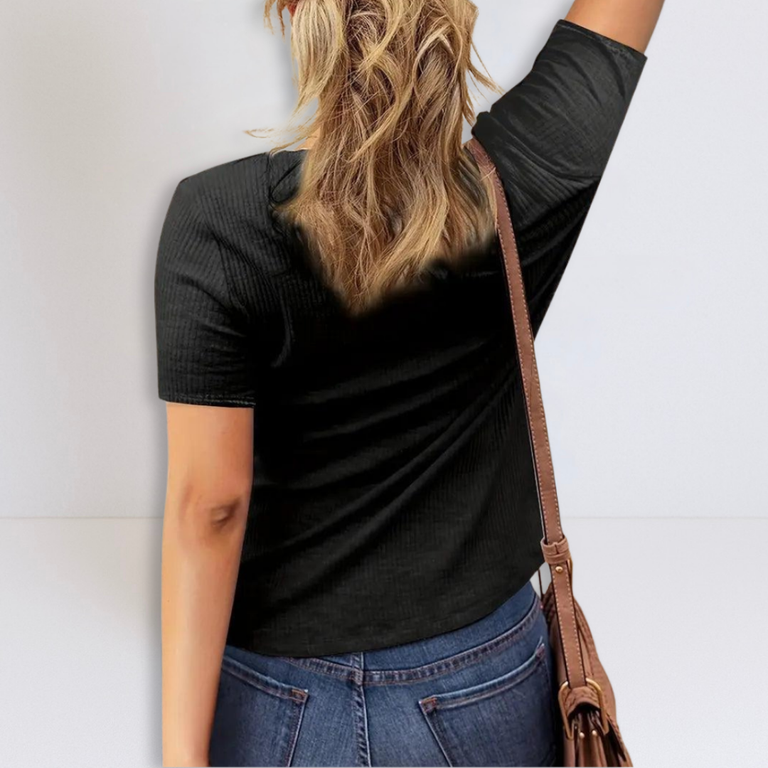 Black ribbed henley blouse seen from side/back with short sleeves and curved hem.
