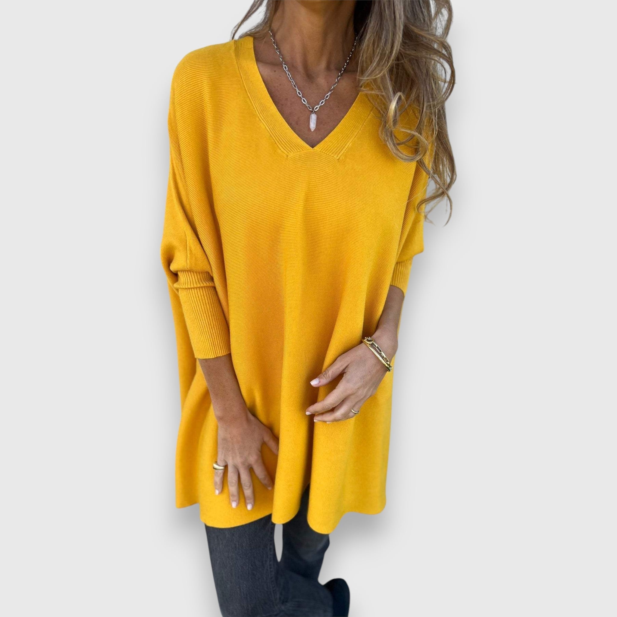 Yellow oversized V-neck sweater with loose knit and long sleeves.