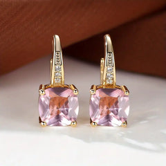 Gold hoop earrings with square pink stones and small clear accents
