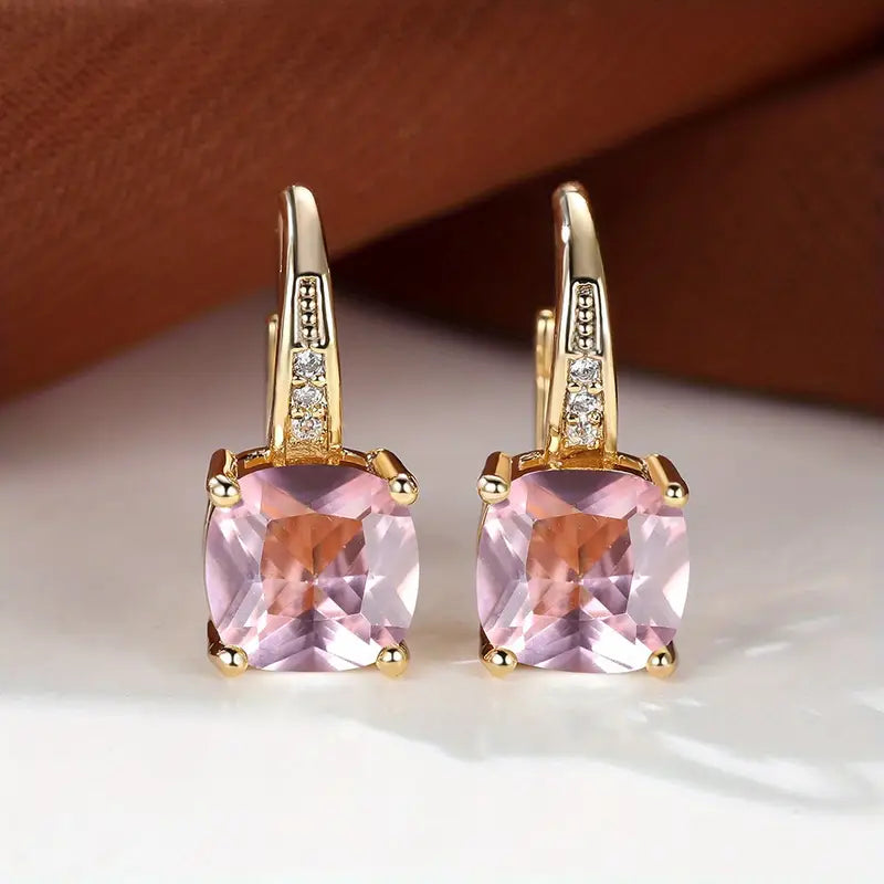 Gold hoop earrings with square pink stones and small clear accents