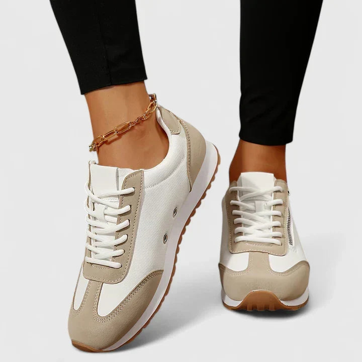 Beige and white comfort sneakers with lace-up front, tan trim, and chunky rubber sole