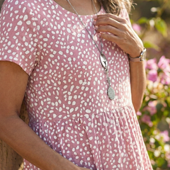 Pink Meadow Drift dress close-up: dotted fabric, gathered waist, short sleeves
