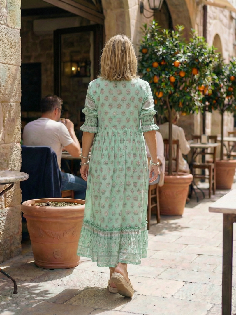 Back view of mint green patterned midi dress with gathered waist and tiered hem