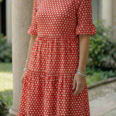 Red polka dot tiered midi dress with short ruffle sleeves and round neckline