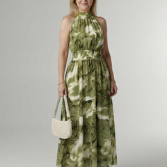 Green gathered halter midi dress with smocked waist, tiered skirt, and hand bag