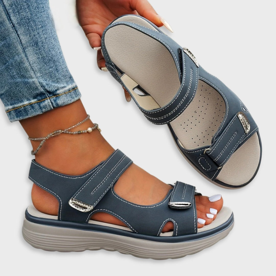 Blue slide sandals with hook-and-loop straps, open toe, and cushioned sole