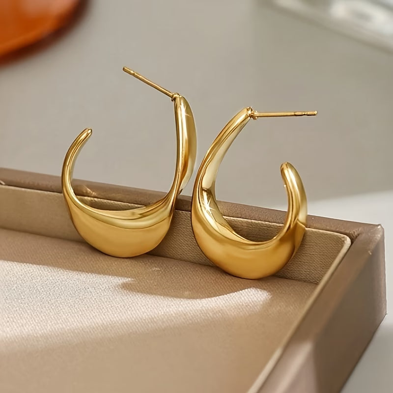 Gold twisted hoop earrings on display box, pair with glossy curved profile