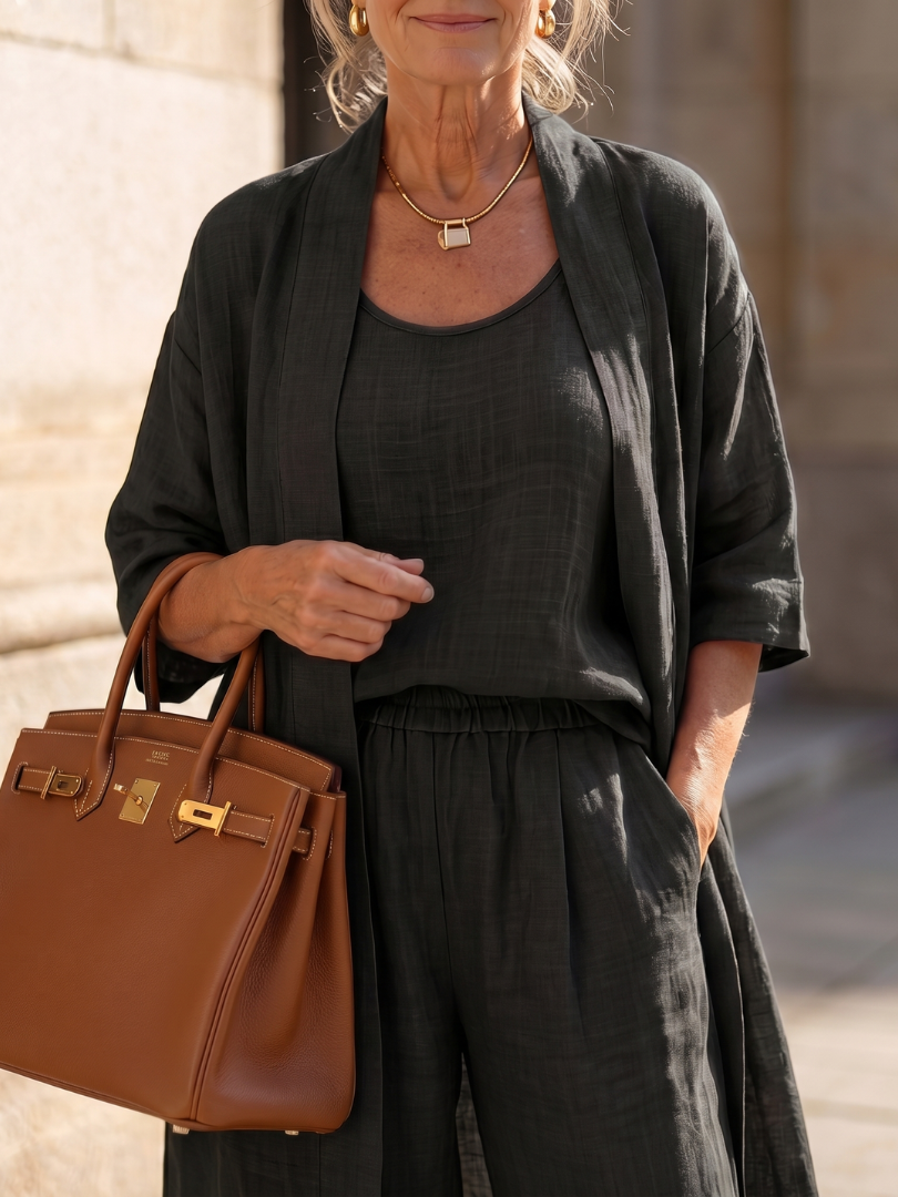 Black relaxed three-piece set with scoop-neck top, buttoned waist, and duster
