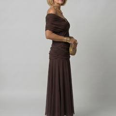 Off-shoulder flow maxi dress in dark brown, side view with draped neckline and pleated skirt