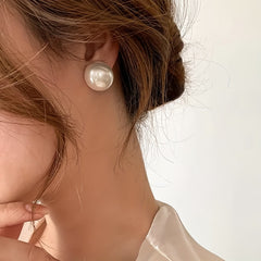 Pearl stud earrings on ear: large round white pearl stud
