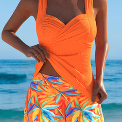 Orange ruched tankini top with draped V neckline and tropical leaf print skirt