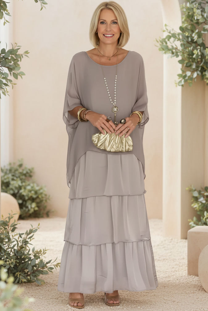 Soft grey tiered long-sleeve dress with draped overlay and round neckline