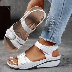 White leather open-toe sandals with two hook-and-loop straps and cushioned wedge sole