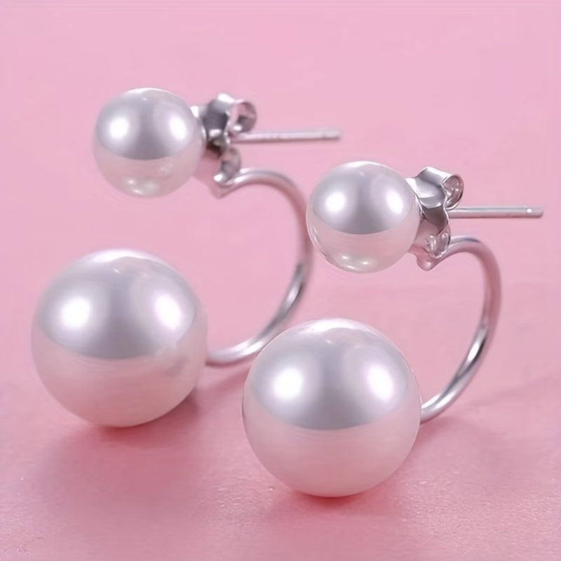 Large double-pearl statement earrings with glossy white spheres on silver hoops