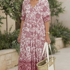 Blush pink bohemian dress with V-neck, short sleeves, tiered floral print.