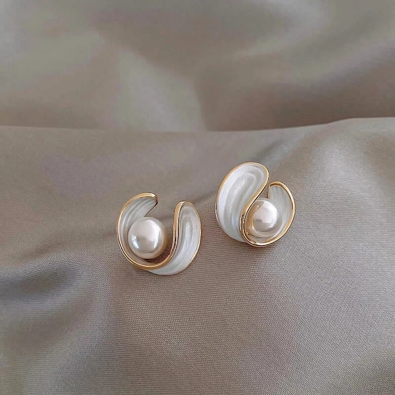 Gold-tone pearl stud earrings with teardrop metal frames and white pearls