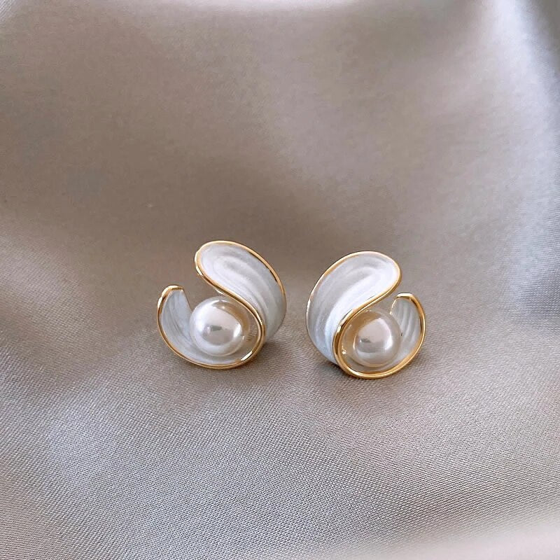 Gold-tone pearl stud earrings with teardrop settings and centered white pearl
