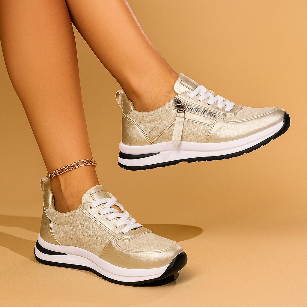 Gold zip-up comfort sneakers with white laces, front zipper tab, and black-trim sole