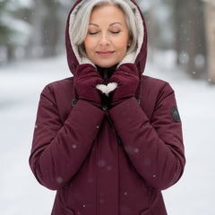 Burgundy sherpa-lined parka with hood and front zip, shown close-up with hands near collar
