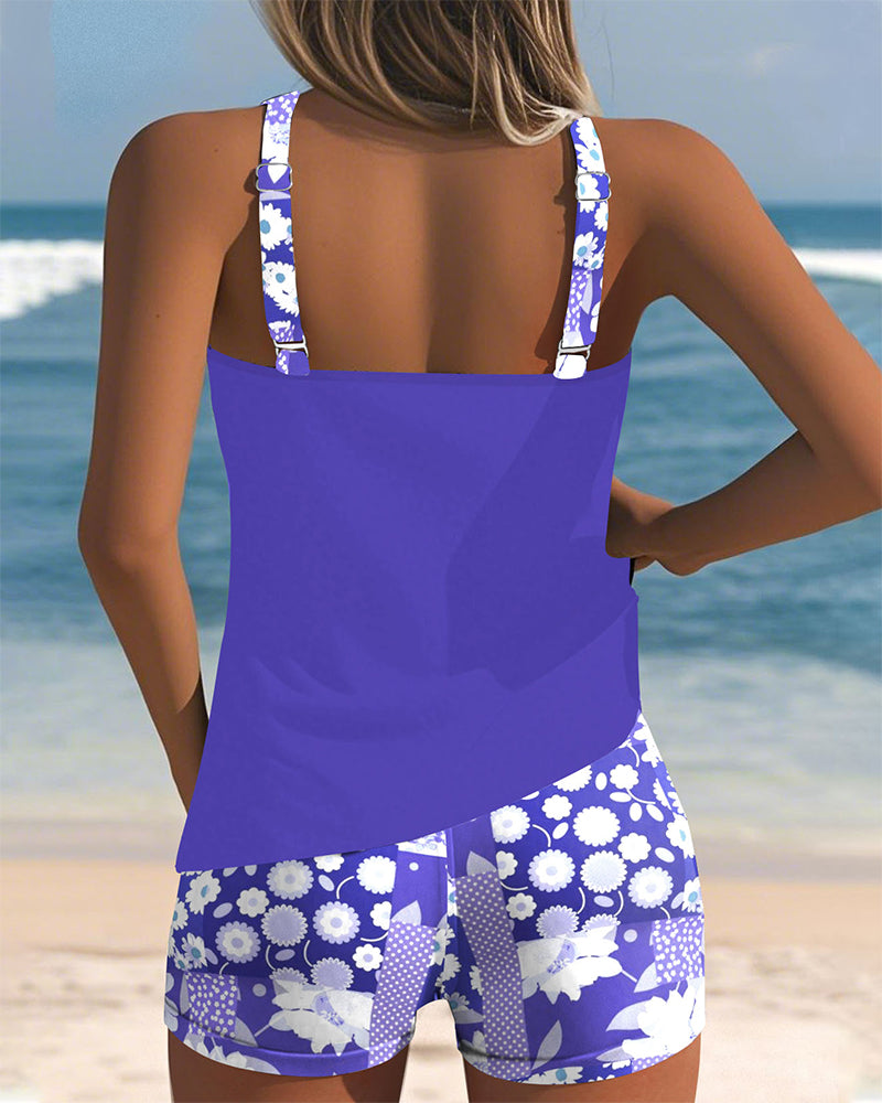 Belly-covering swim set, purple racerback tank and blue floral patterned swim shorts, back view
