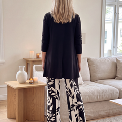 Black three-piece set, back view: long cardigan and leaf-print wide-leg pants