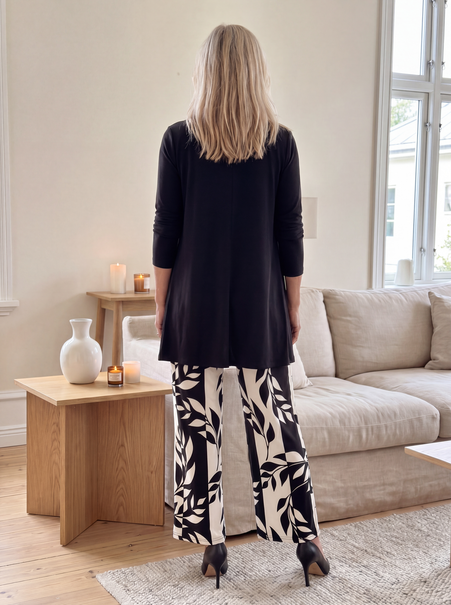 Black three-piece set, back view: long cardigan and leaf-print wide-leg pants