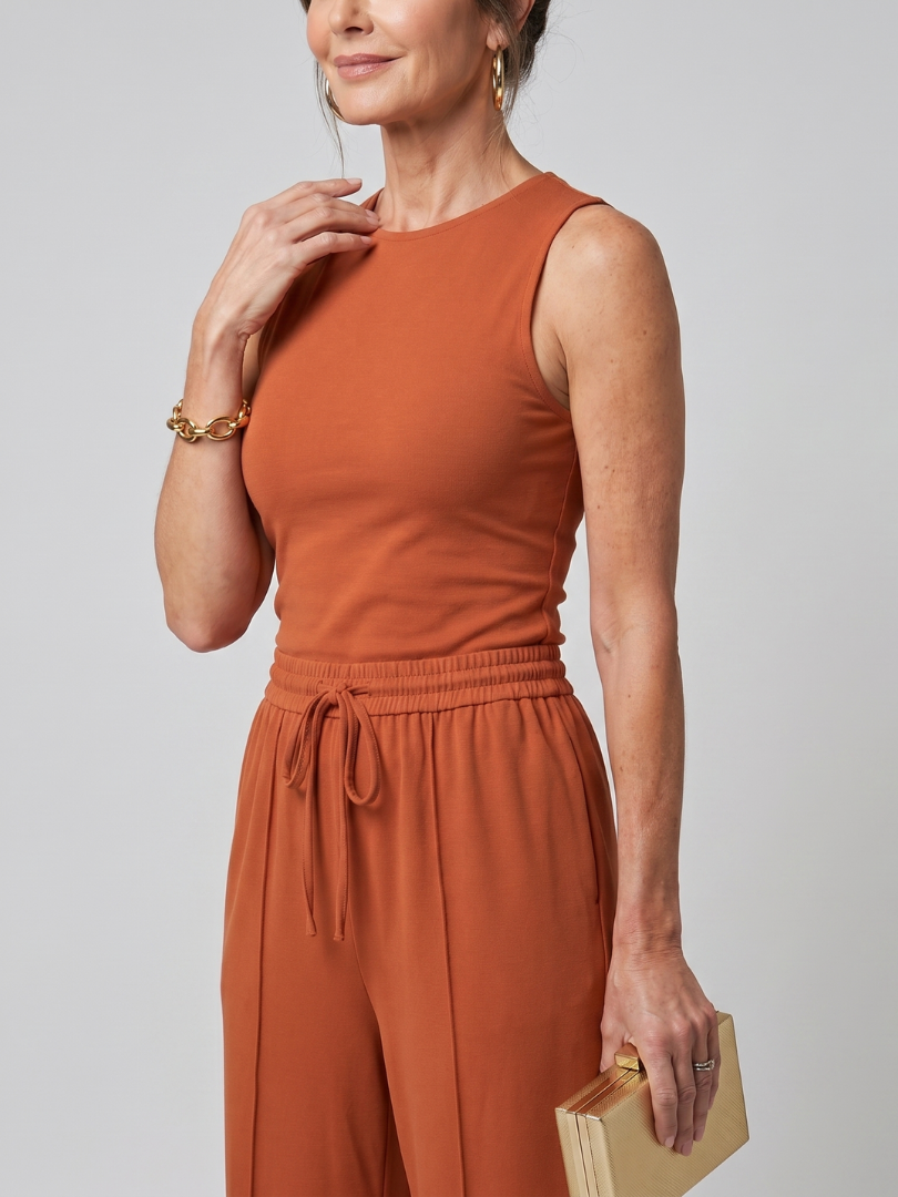 Rust-orange sleeveless top and matching wide-leg pants with elastic drawstring waist