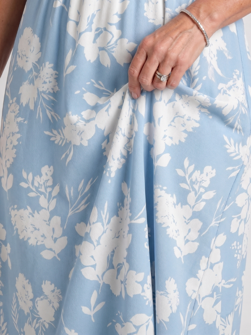 Close-up of light blue floral fabric with V-neck bodice and gathered skirt detail