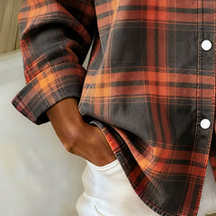 Plaid shirt sleeve and side hem detail in orange, rust, and dark charcoal