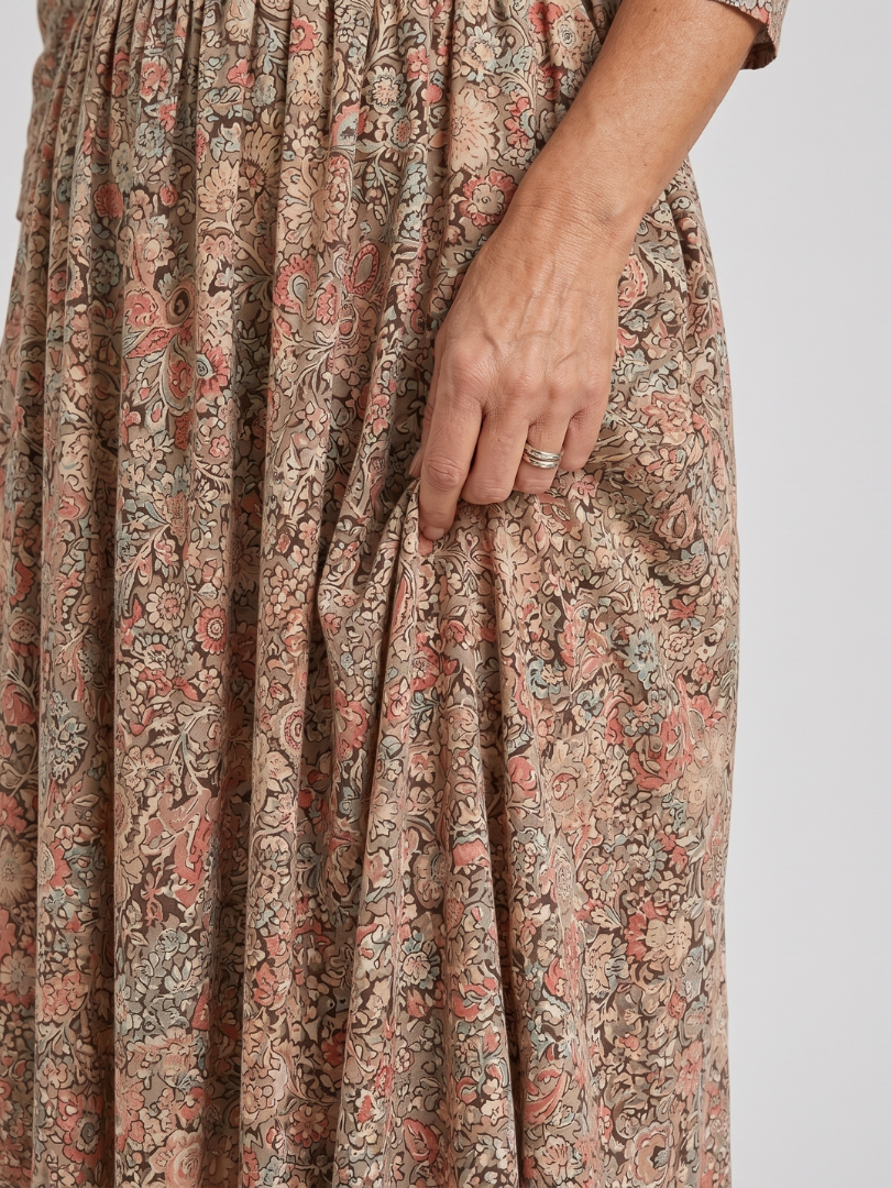 Floral midi dress close-up showing pleated bodice and full gathered skirt