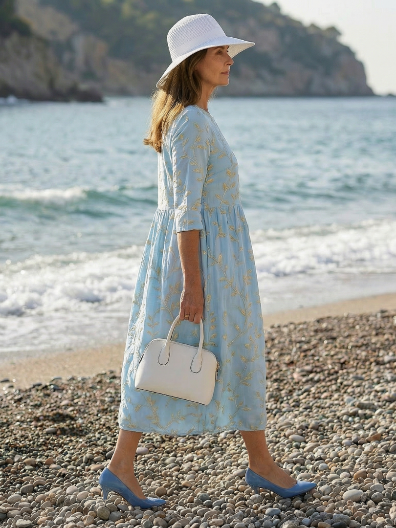 Sky blue garden-print midi dress with gold leaf pattern, three-quarter sleeves, tiered skirt