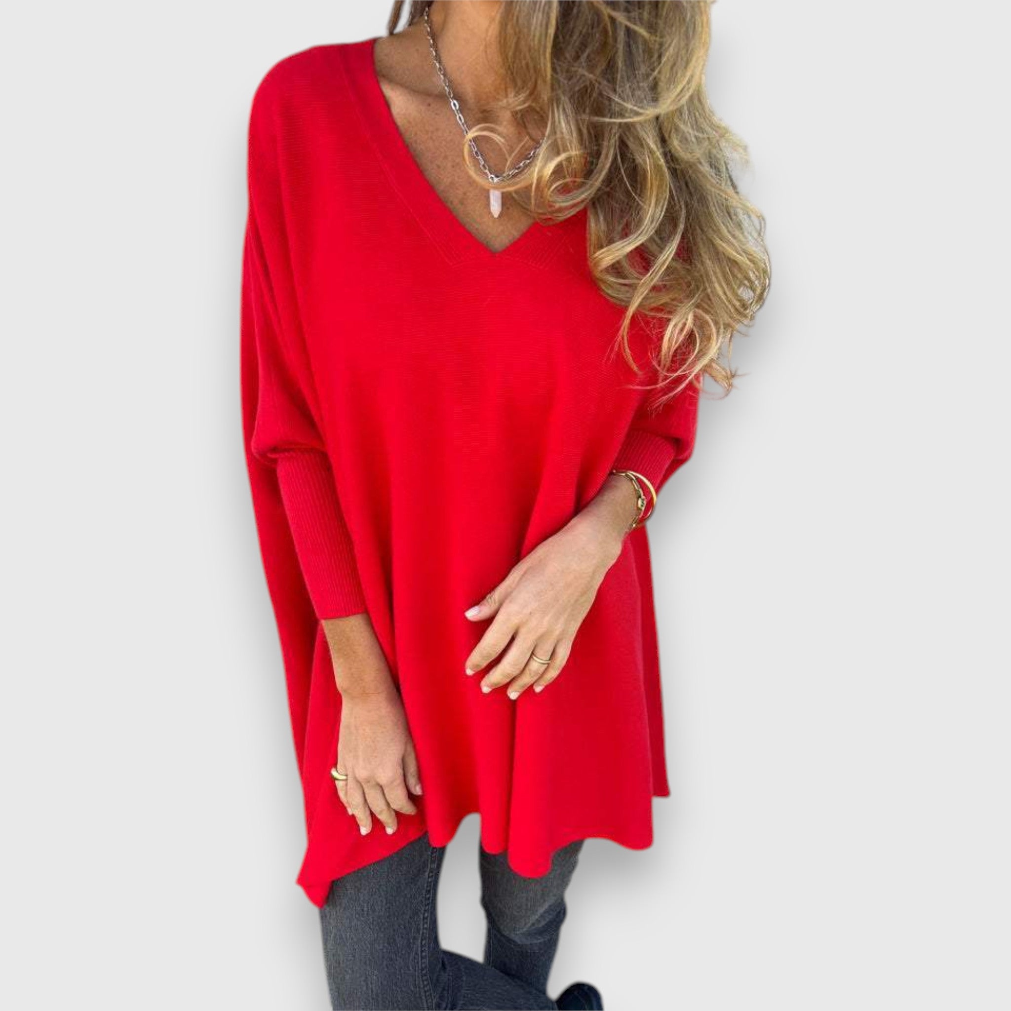 Red oversized V-neck sweater with loose knit and long sleeves.