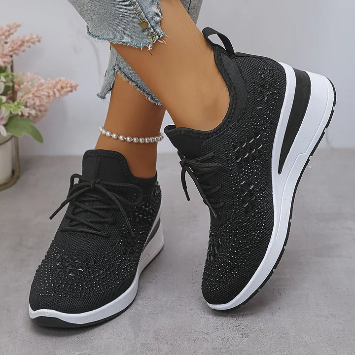 Black knit comfort sneakers with lace-up front, white midsole, textured rhinestone upper