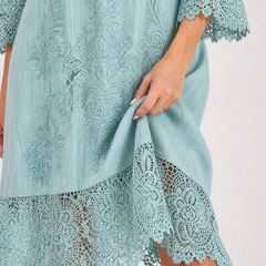Light blue embroidered dress with decorative motif and lace-trimmed edge