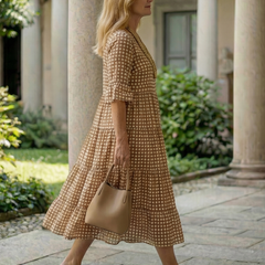 Brown polka dot tiered midi dress in side view, short sleeves and tiered skirt