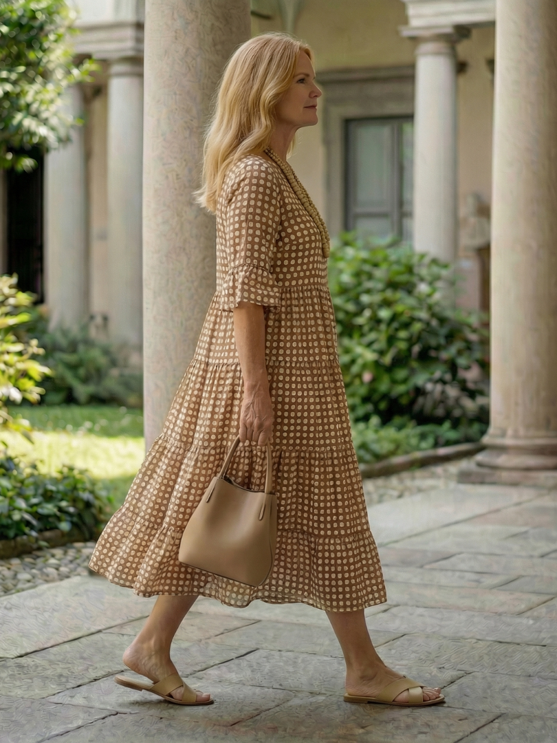 Brown polka dot tiered midi dress in side view, short sleeves and tiered skirt