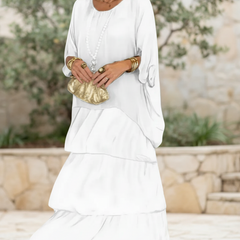 Soft white tiered long-sleeve dress with draped overlay and round neckline