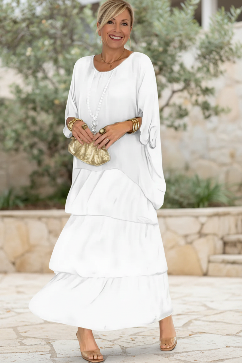 Soft white tiered long-sleeve dress with draped overlay and round neckline