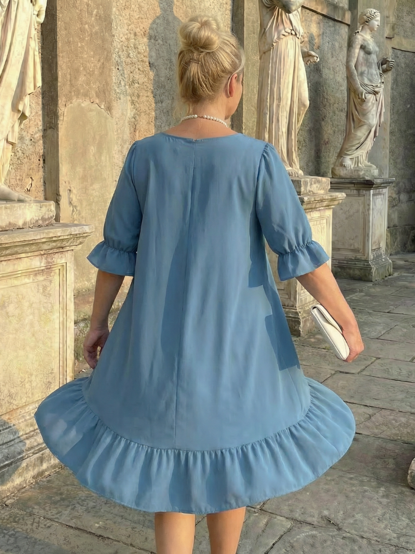 Blue ruffle day dress back view with gathered hem and elbow-length puff sleeves