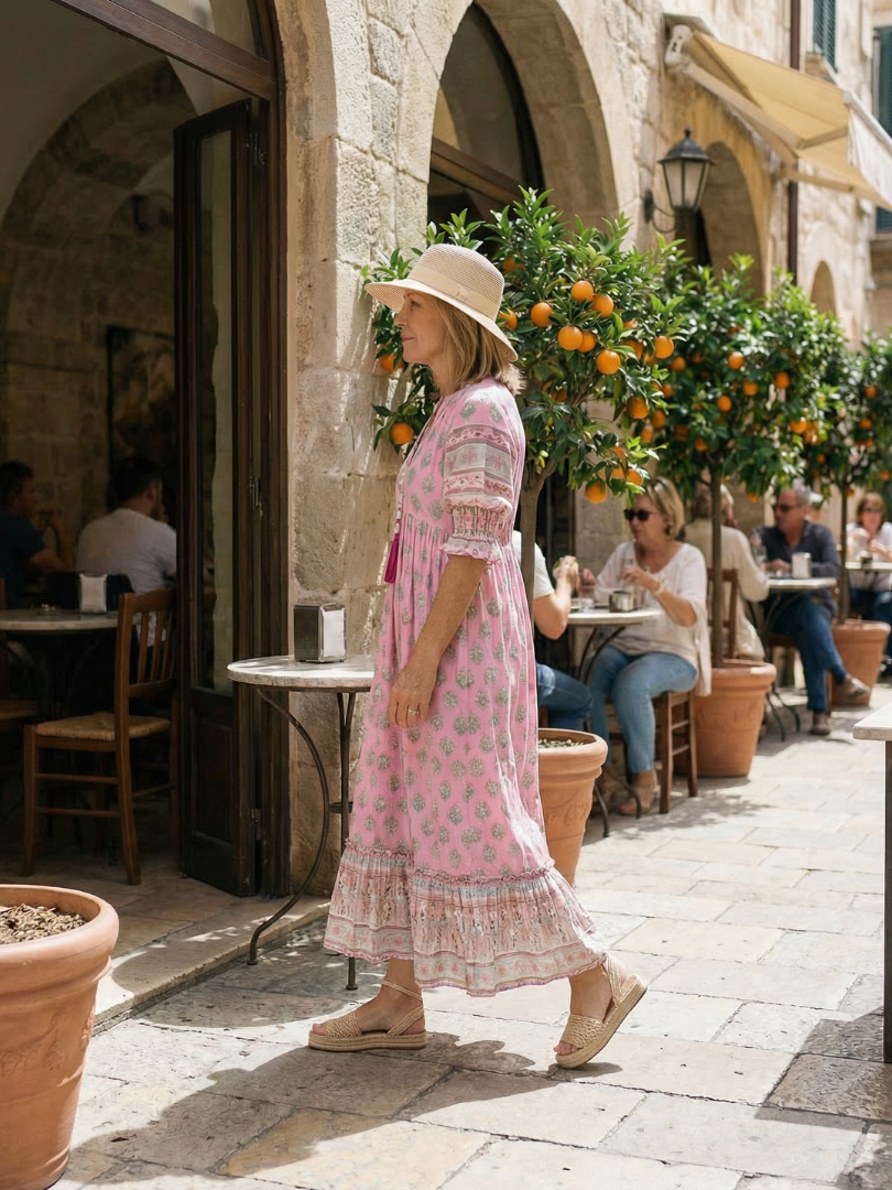 Pink V-neck tiered midi dress with short puff sleeves, side view, patterned print